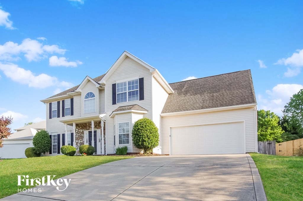 A large white house with a garage is shown in the image.