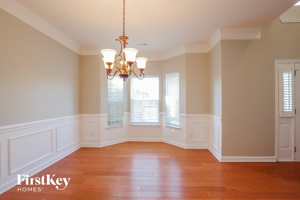 A room with wooden floors and a chandelier hanging from the ceiling.