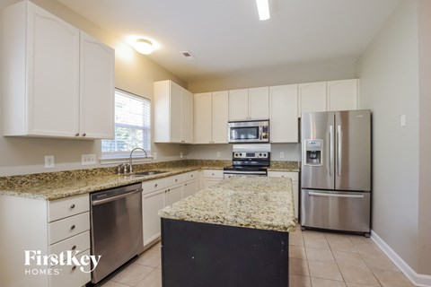 A kitchen with granite countertops and stainless steel appliances.