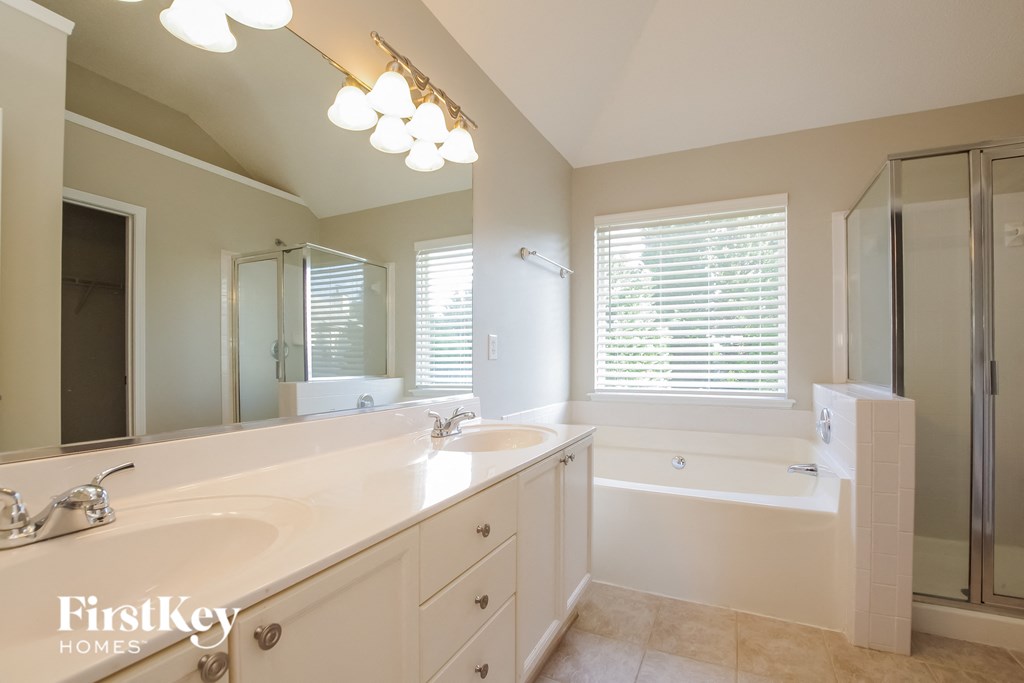 A bathroom with a white tub and sink.