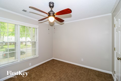 a bedroom with a ceiling fan and a window