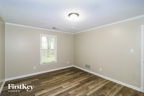 the spacious dining room with hardwood flooring and a window