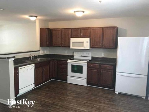 A kitchen with wooden cabinets and white appliances.