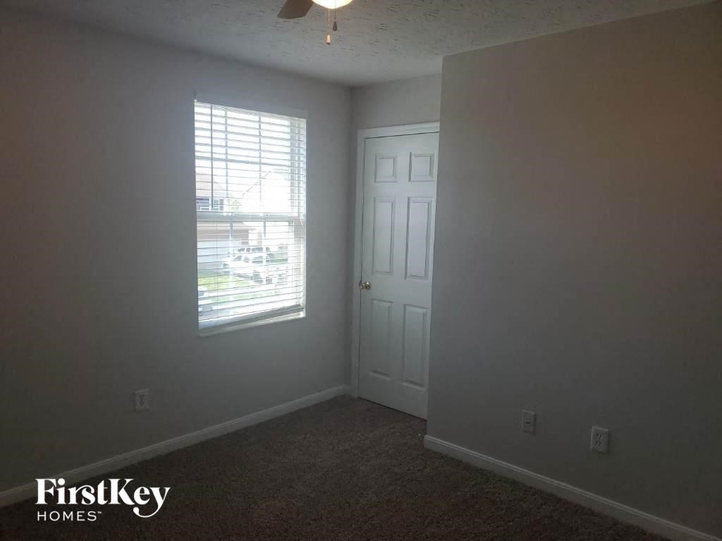 a bedroom with a window and a white door