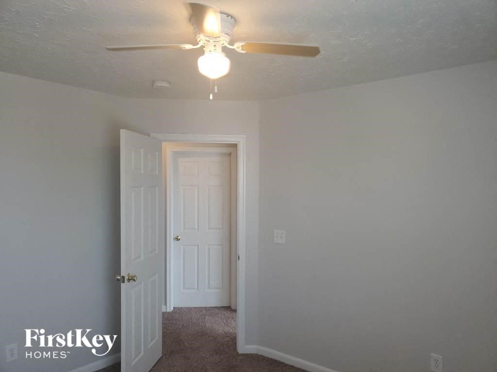 a bedroom with a ceiling fan and a door to a closet