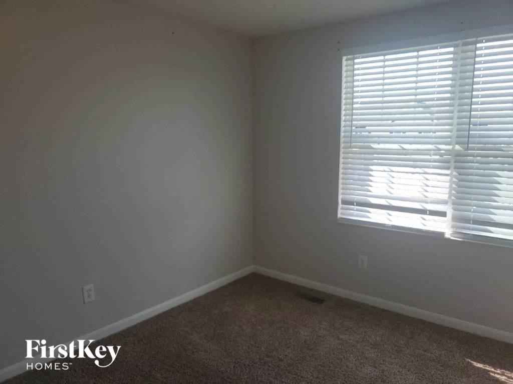 a small room with a window and a carpet