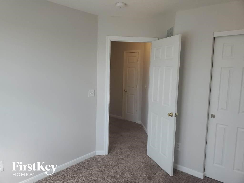a bedroom with a closet and a door to a hallway