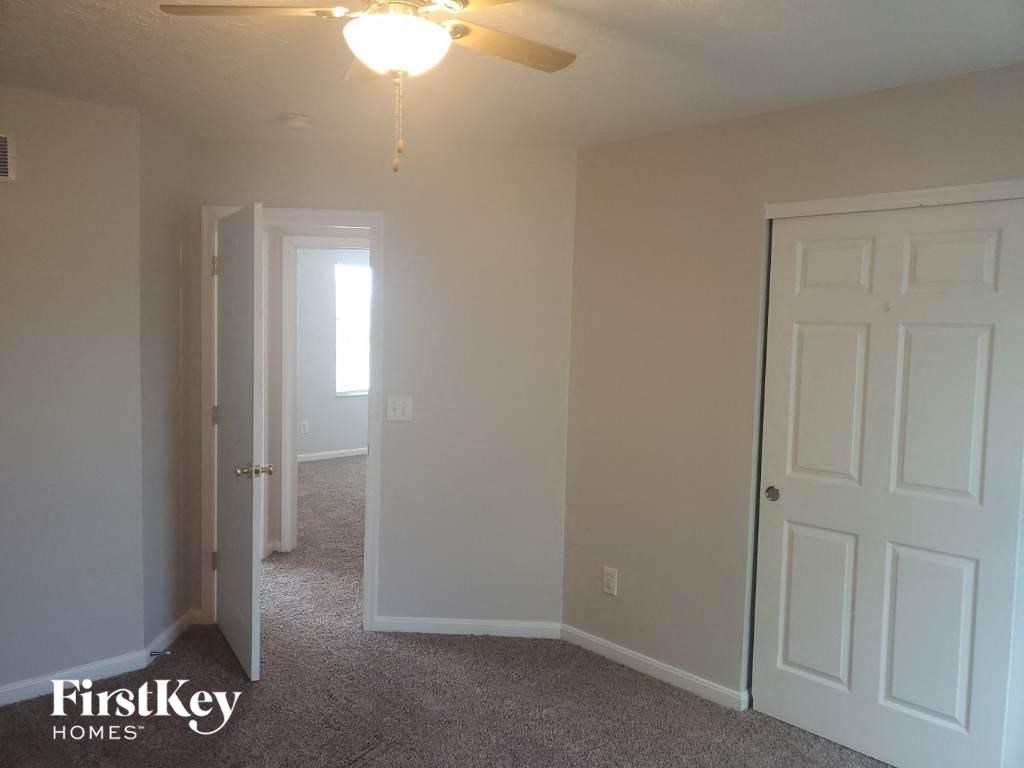 a bedroom with a white door and a ceiling fan