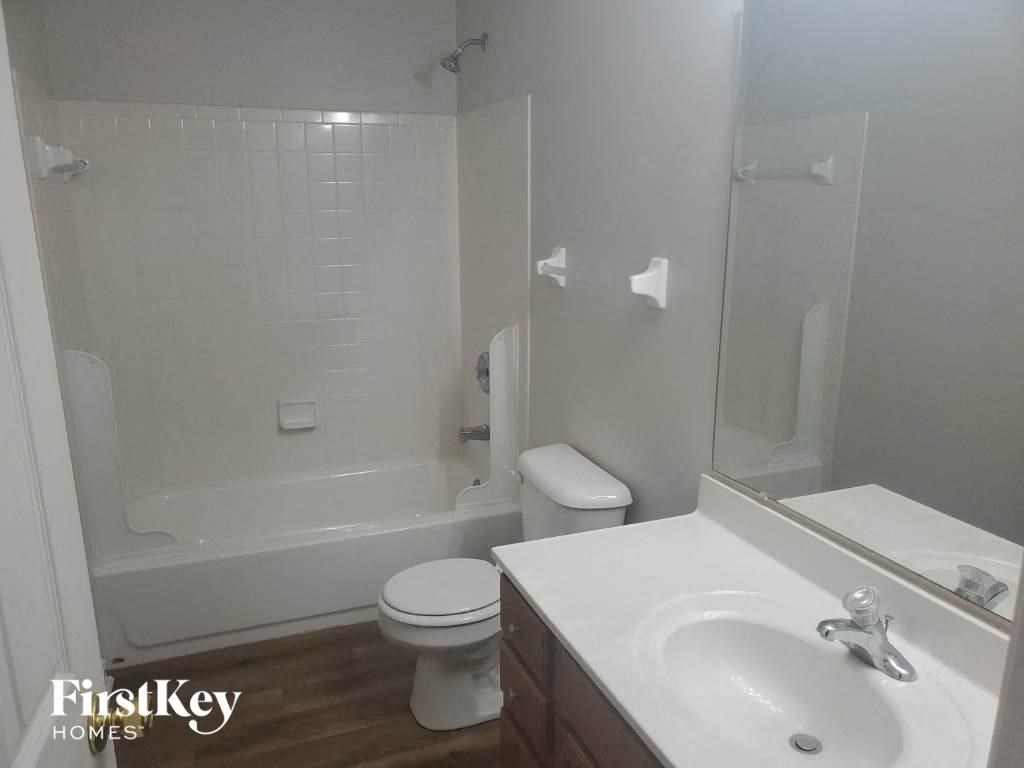 a white bathroom with a sink toilet and shower