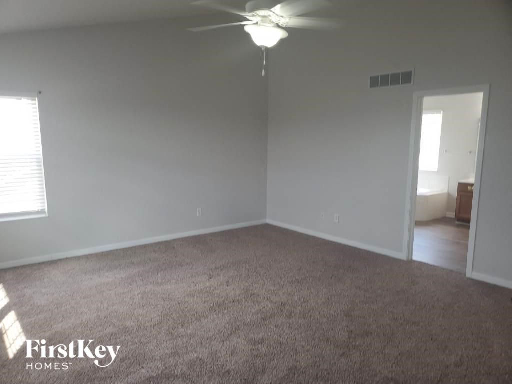 an empty living room with a ceiling fan