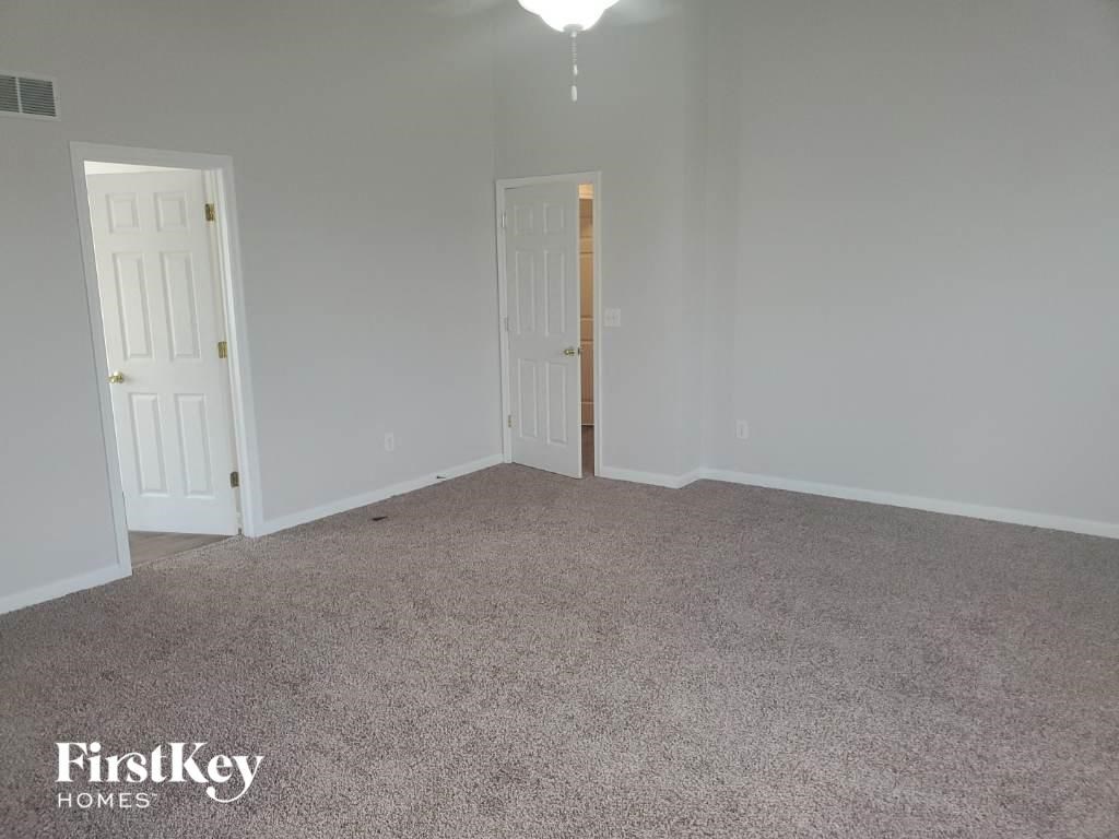 a bedroom with a carpeted floor and two doors