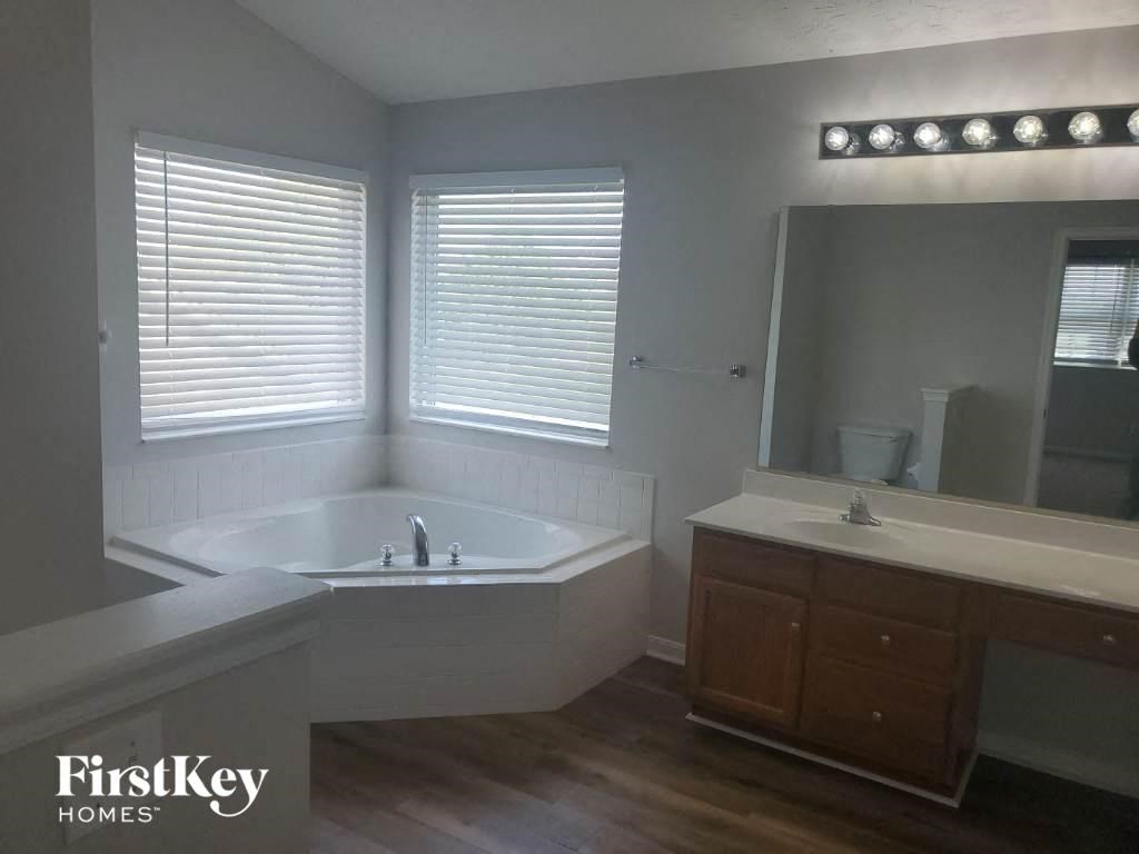 a bathroom with a tub and a sink and a mirror