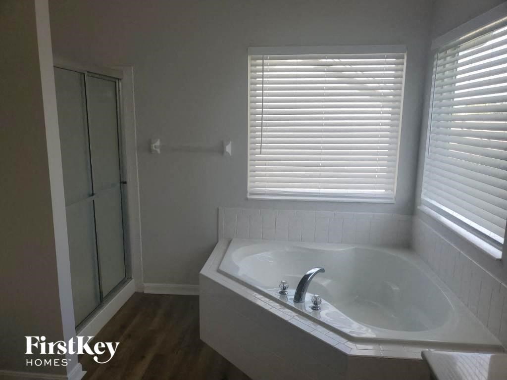 a bathroom with a tub and a shower and a window