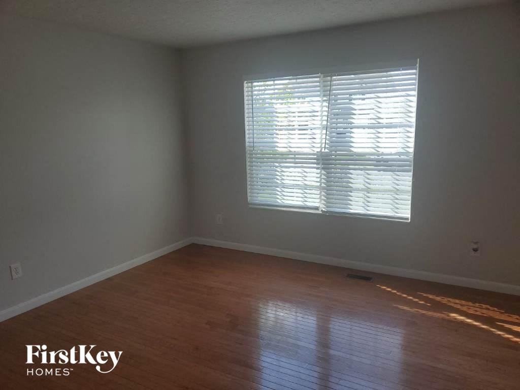 an empty room with wood floors and a window