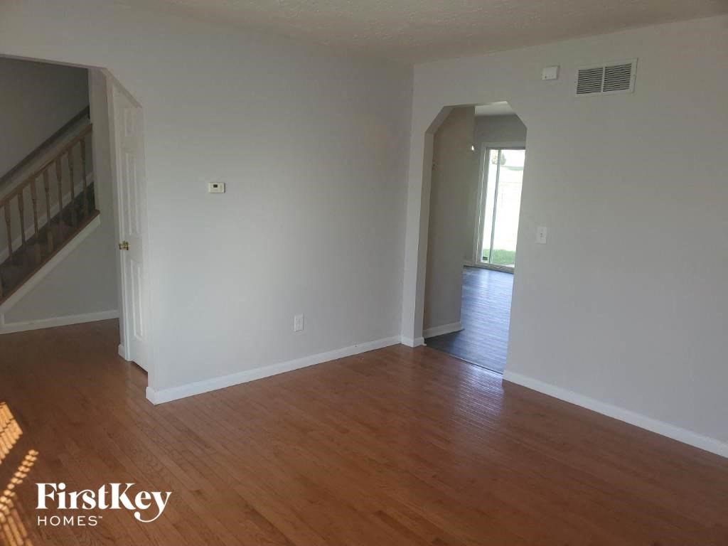 an empty living room with white walls and wood floors