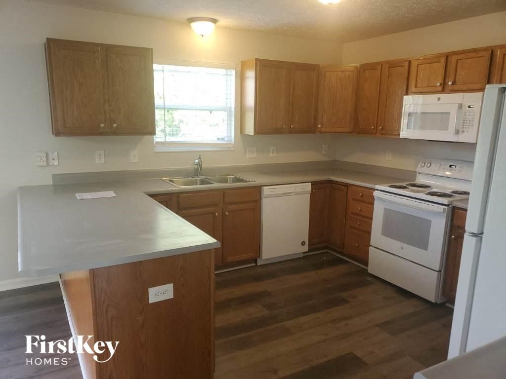 an empty kitchen with wooden cabinets and white appliances