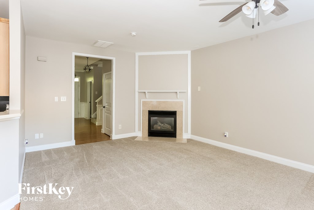 a living room with a fireplace and a ceiling fan