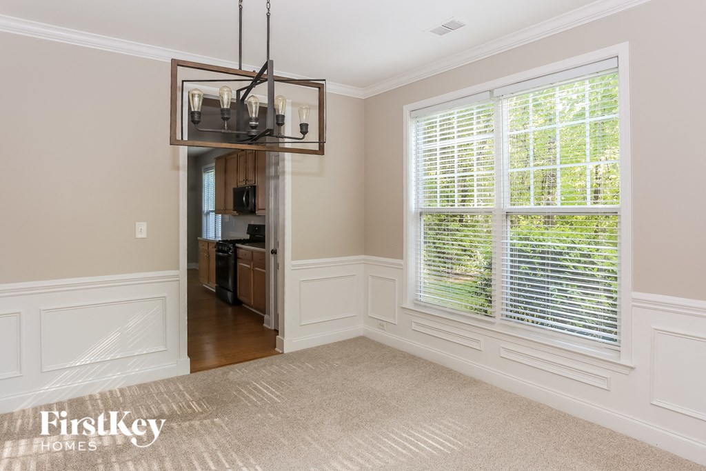 a dining room with a large window and a rug