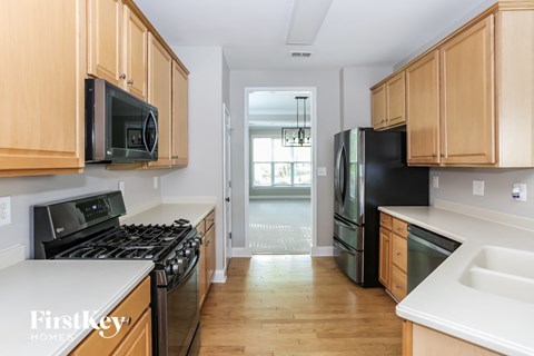 a kitchen with wooden cabinets and black appliances and white counter tops