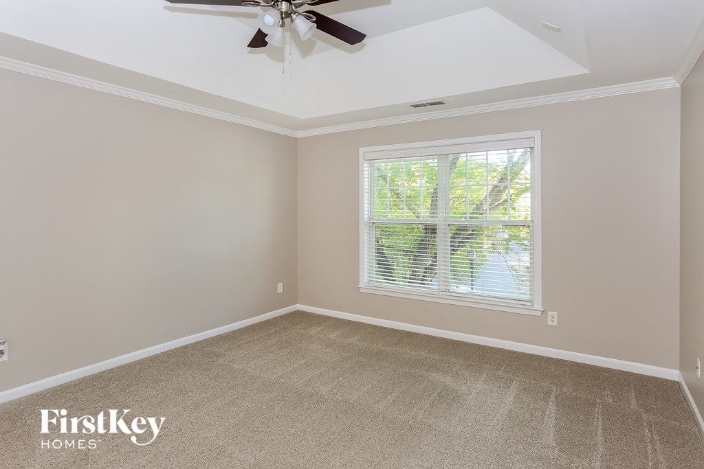 a empty room with a ceiling fan and a window