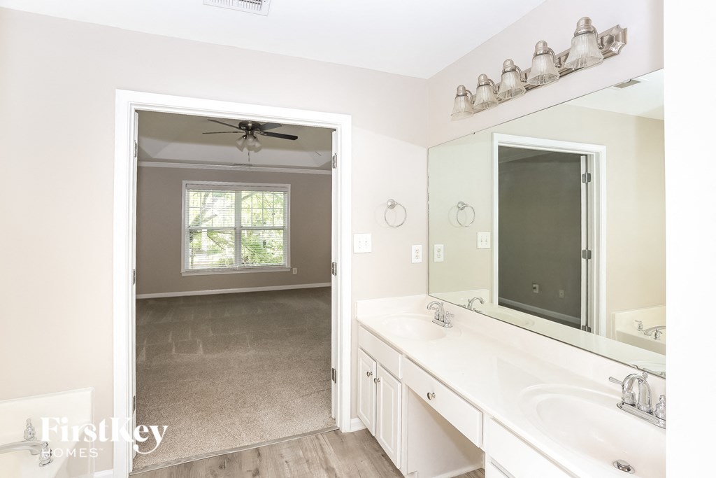 a white bathroom with a large mirror and a white sink