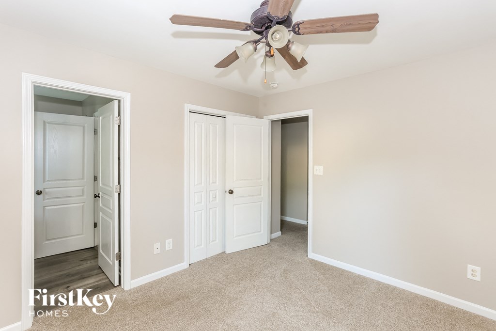 a bedroom with a ceiling fan and a closet
