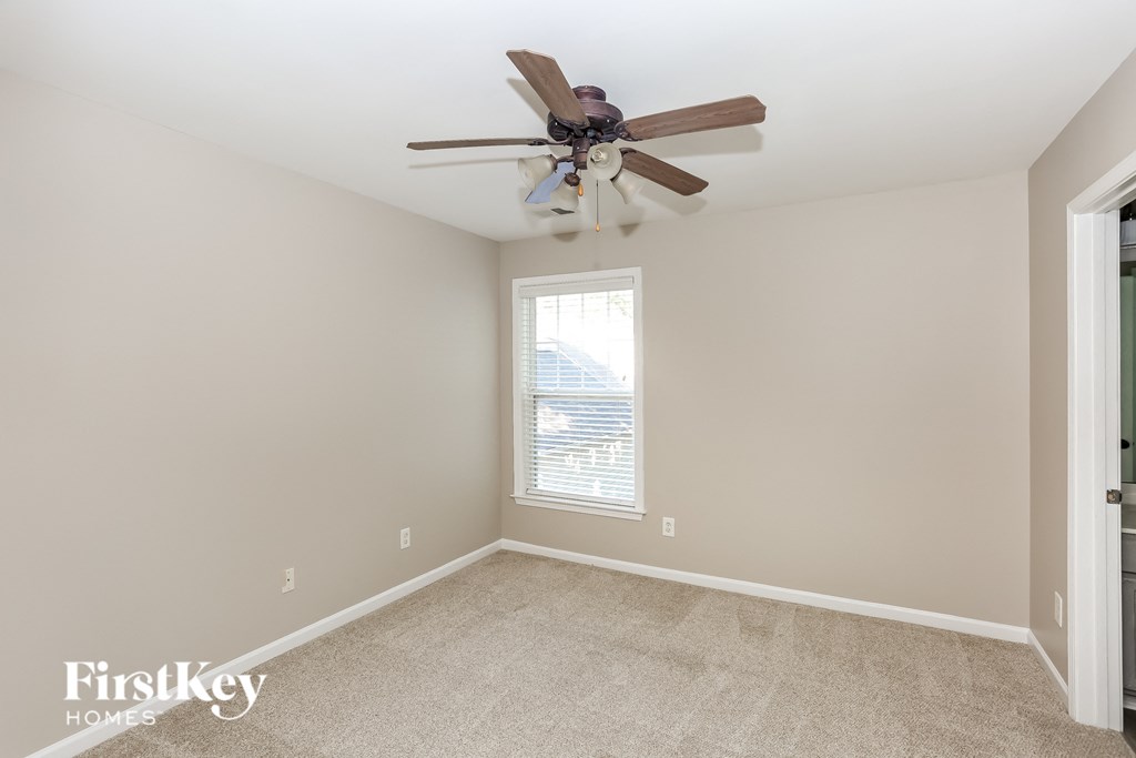 a bedroom with a ceiling fan and a window