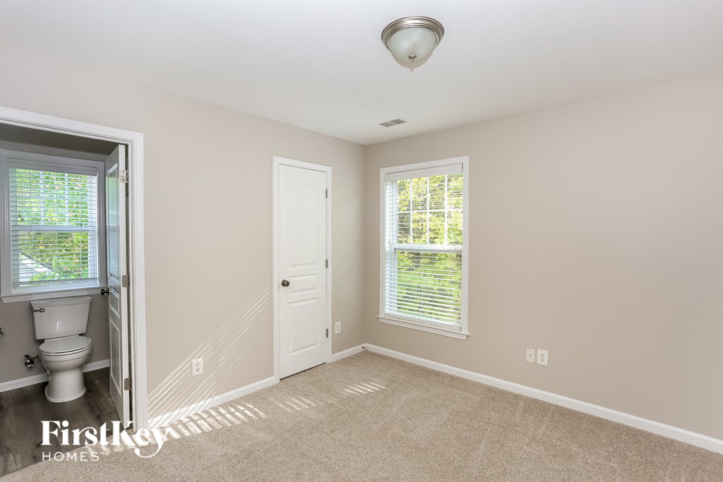 a small bathroom with a toilet and a white door and window