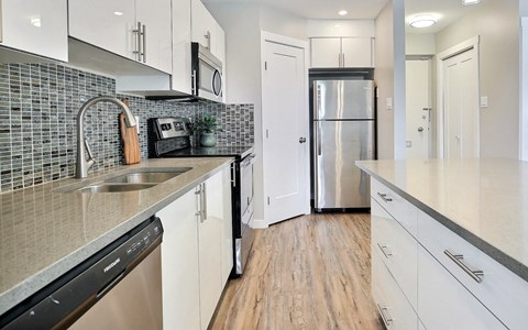 a kitchen with white cabinets and a stainless steel refrigerator