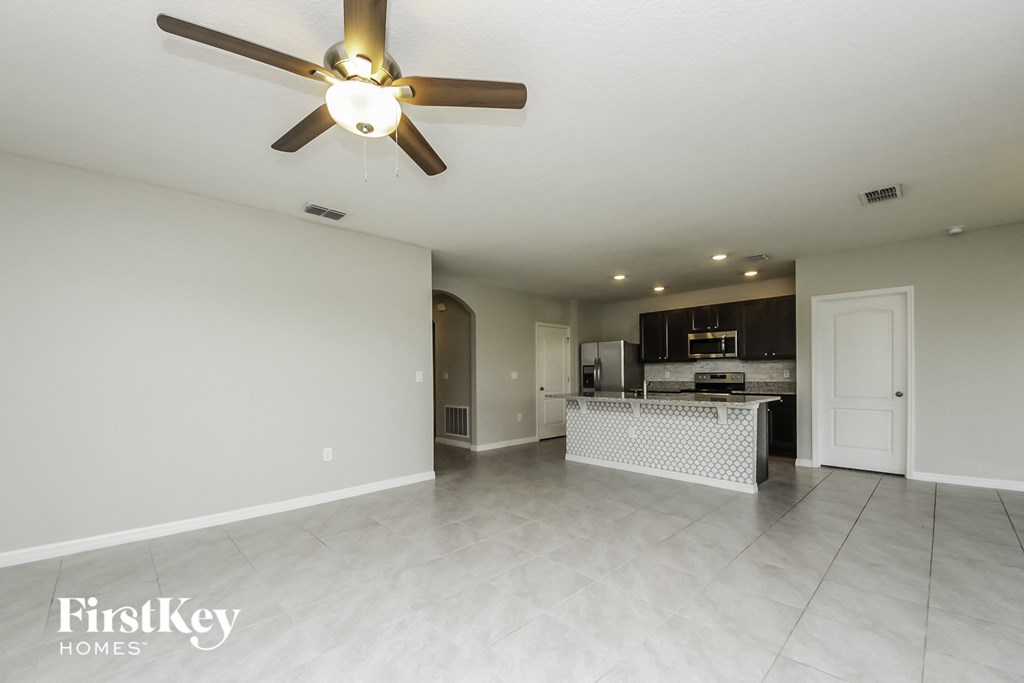 an open kitchen and living room with a ceiling fan