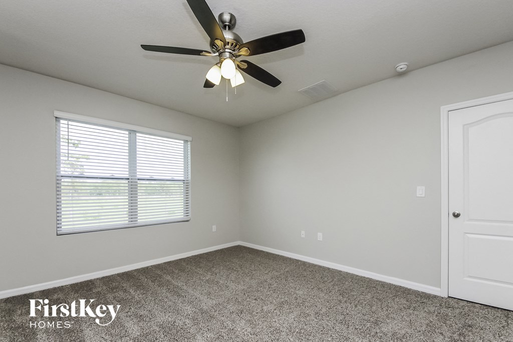 the master bedroom has a ceiling fan and carpeted flooring