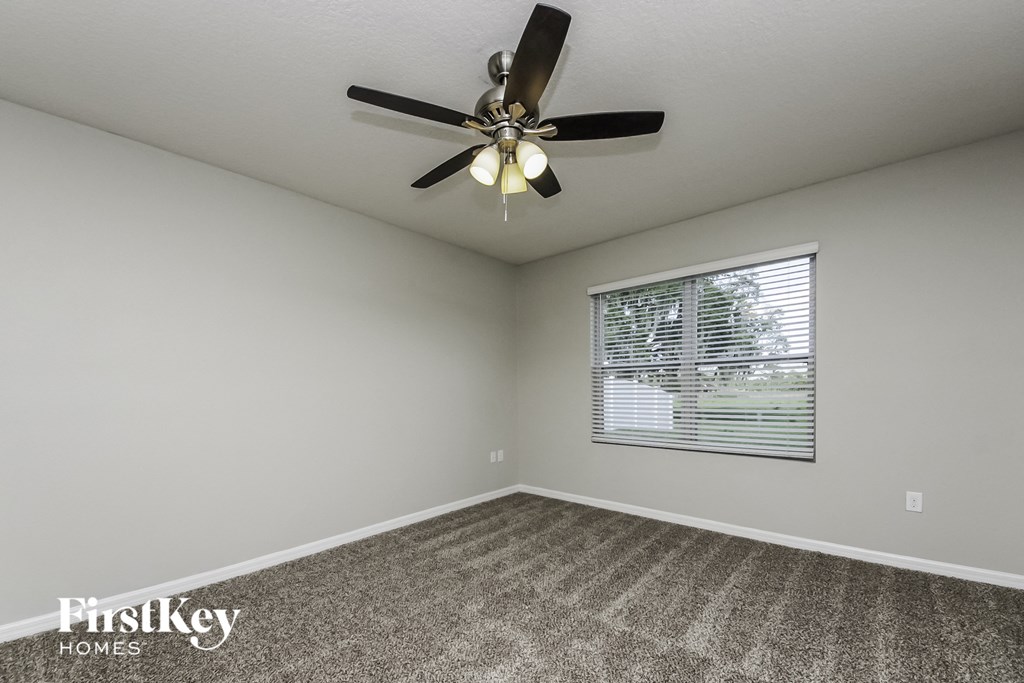 the living room has a ceiling fan and a window