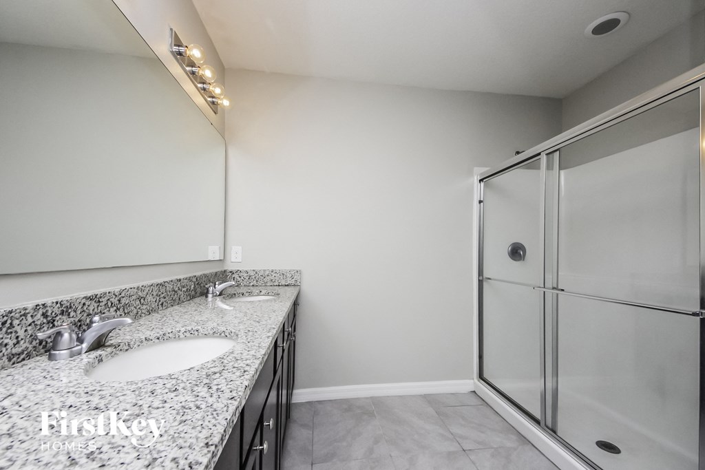 a bathroom with granite counter tops and a shower
