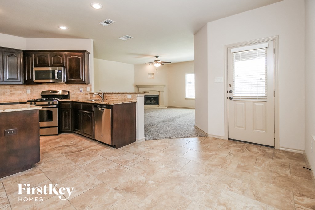 an empty kitchen with a door to the living room