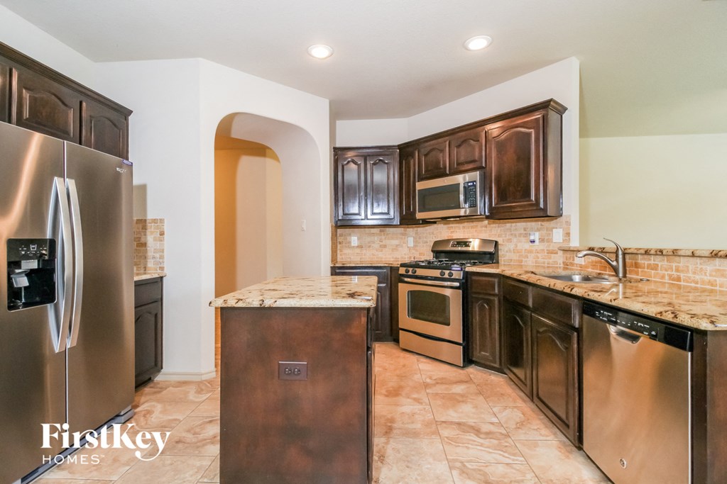 a kitchen with stainless steel appliances and wooden cabinets