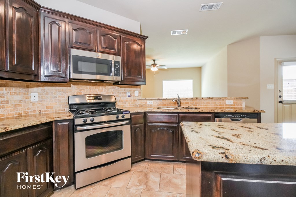 a kitchen with wooden cabinets and stainless steel appliances