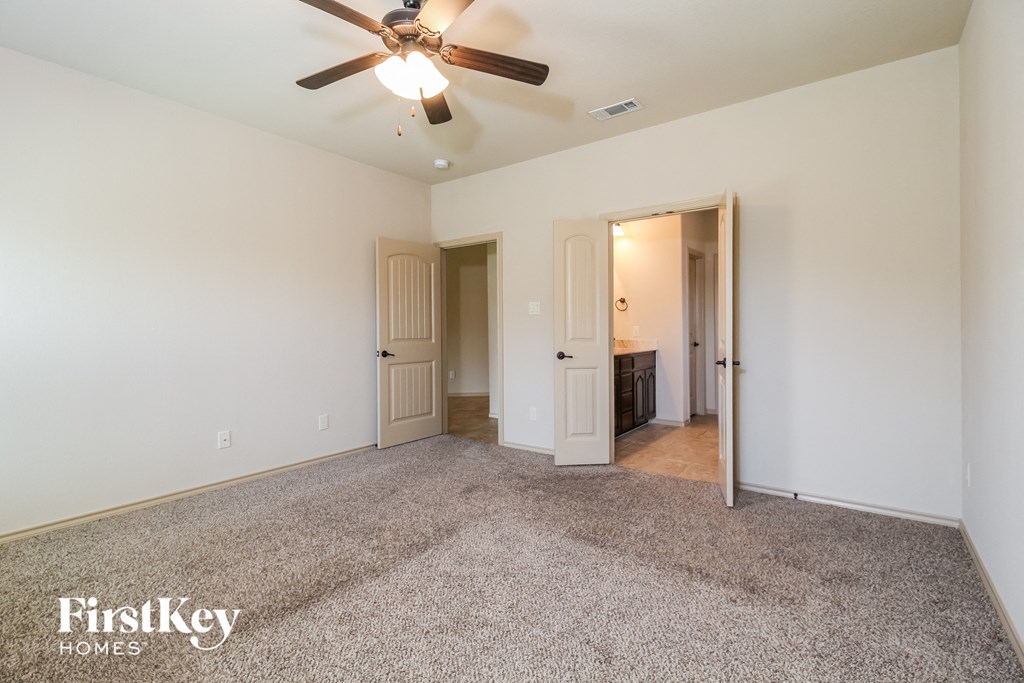a living room with carpet and a ceiling fan