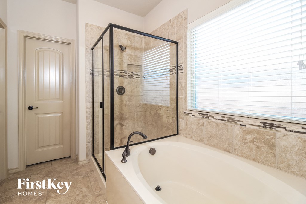 the master bathroom has a large soaking tub and a walk in shower