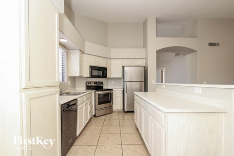 a large kitchen with white cabinets and stainless steel appliances