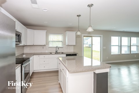 A modern kitchen with white cabinets and a large island.