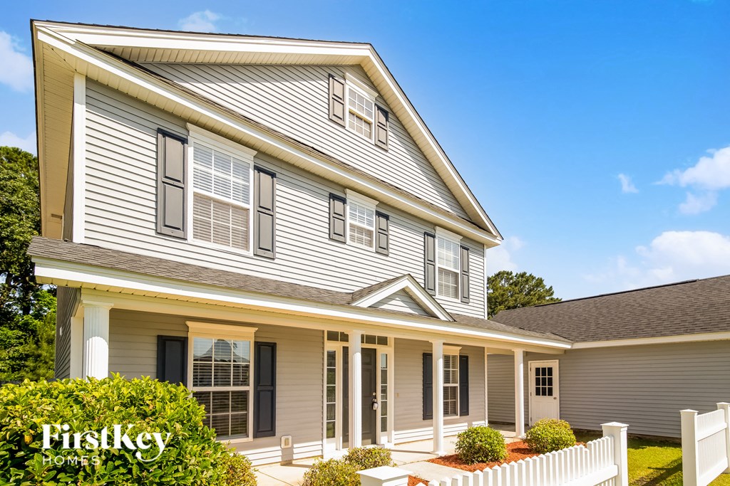 a house with a white fence in front of it