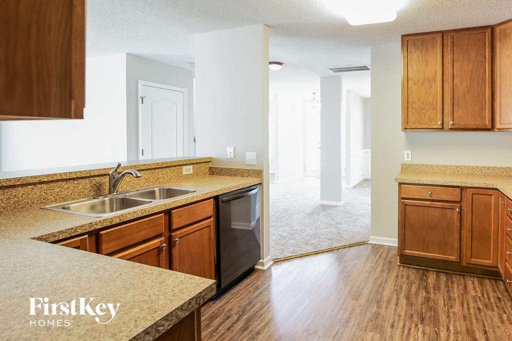 a kitchen with wood flooring and a sink and wooden cabinets