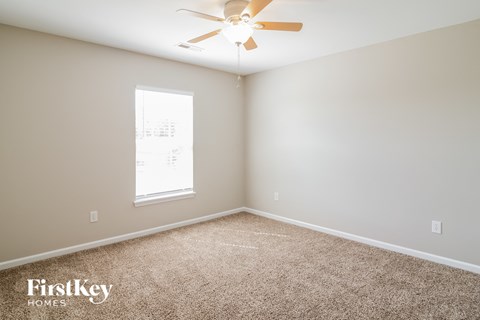a bedroom with carpet and a ceiling fan
