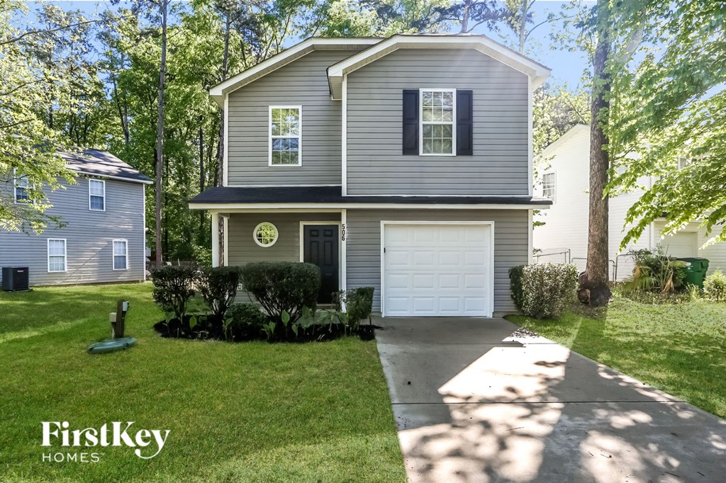 a gray house with a white garage door and a lawn
