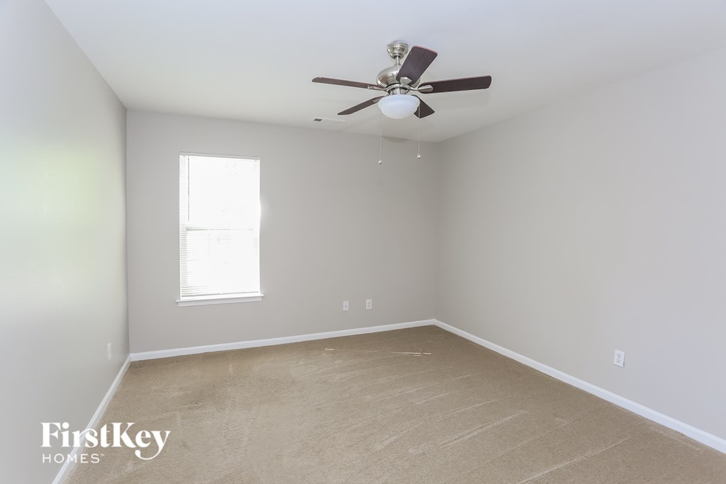 a empty room with a ceiling fan and a window