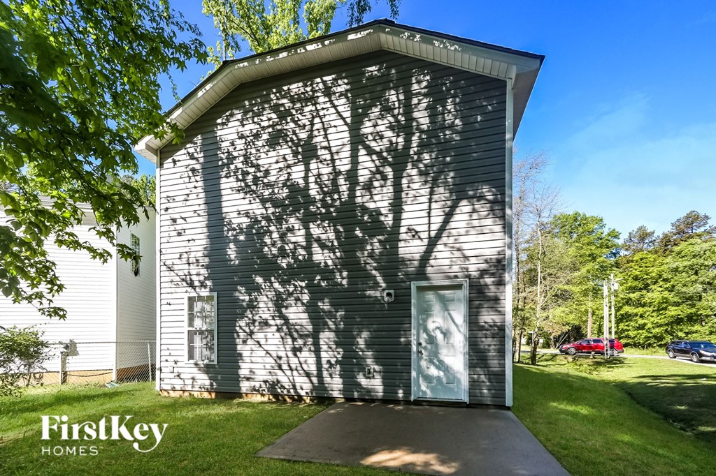 the shadow of a tree on the side of a small building