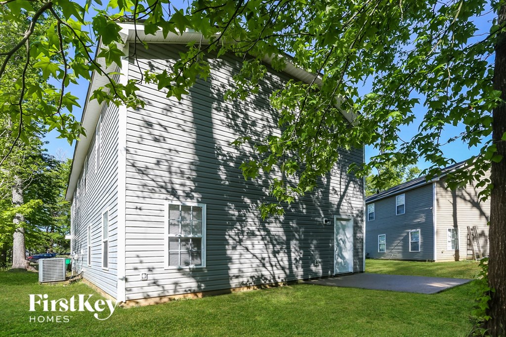 a white and green house with a tree in front of it