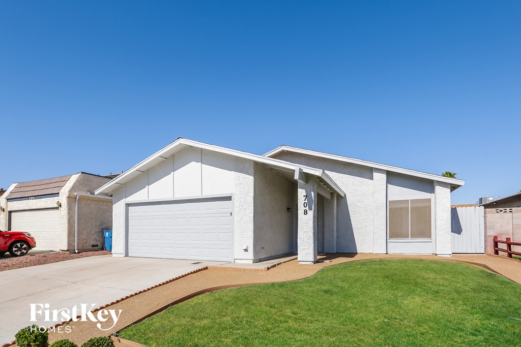 a white house with a garage and a green lawn