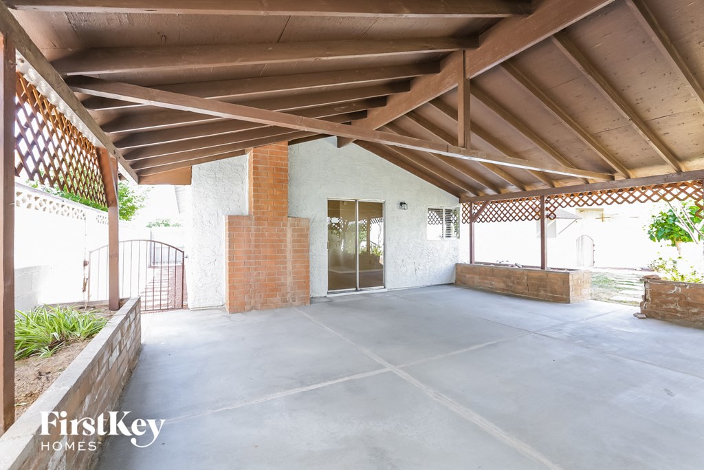 a covered porch with a brick wall and a wooden roof