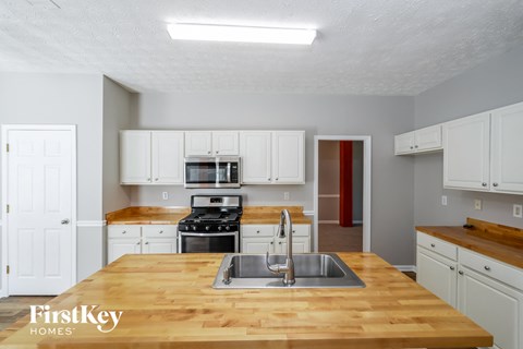 a kitchen with a wooden counter top and a sink
